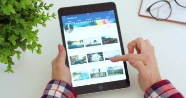 New York - 15 Mayıs 2020: Siyah tablet, Youtube uygulaması kullanan ve seyahatler hakkında video izleyen Kafkasyalı kadının elinde. Kadın bilgisayarda tıkırdıyor ve kayıyor. Uçak yolculukları.
