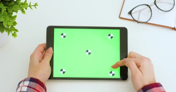 Computador tablet horizontal com tela verde em mãos de mulher caucasiana. Rolagem feminina, zoom e tocando na tela de tecla chroma do dispositivo preto com movimento de rastreamento na mesa. Navegação on-line . — Vídeo de Stock