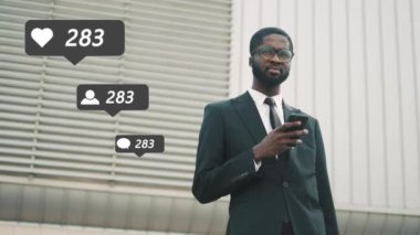 Takım elbiseli, kravatlı ve gözlüklü Afro-Amerikalı genç yakışıklı iş adamı akıllı telefondaki reklam mesajlaşması. Sosyal medyada birçok beğeni, yorum ve yeni takipçiye ulaşılıyor.
