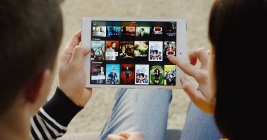 New York - 01 Aralık 2017: Netflix 'in tablet cihazındaki kadın ve erkeğin omuz manzarası üzerinden bir seri açılışı. Kapatın. Üst görünüm