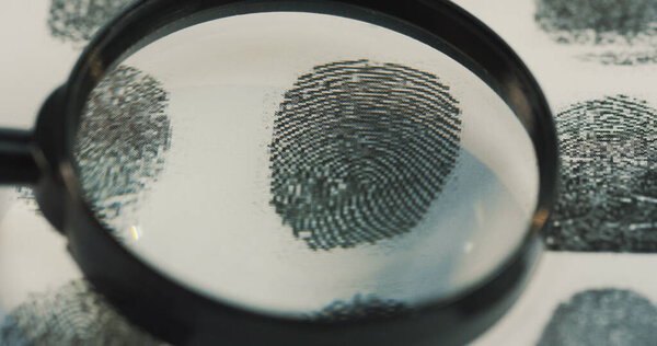 Macro shooting of the investigation of the fingerprints with a magnifying glass. Close up