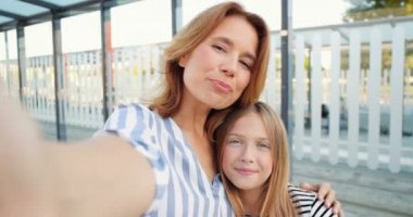 Kafkasyalı güzel bir kadın ve küçük bir genç kızı var. Video kaset takıyor, gülümsüyor ve elleriyle el sallıyor. Güzel anne ve küçük kız kamerayla konuşurken görüntülü sohbet ediyorlar..