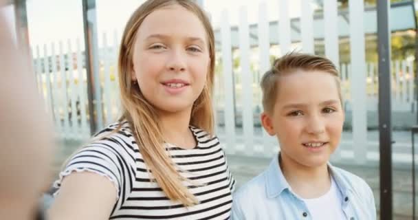 POV of Caucasian small cute children, sister and brother talking to camera and videochatting. Outdoor. Little girl and boy having videochat on webcam. Kids speaking at street on gadget. Close up. — Stock Video