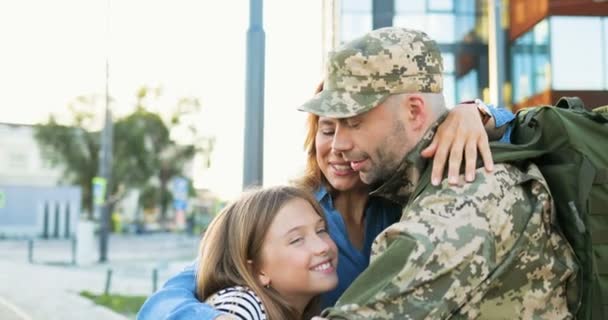 Glückliche junge kaukasische Vater Offizier Treffen und Umarmung niedlichen kleinen Kind und Frau auf der Straße. Schöner Soldat in Uniform kehrt von der Armee zurück und trifft Frau mit Tochter Kriegsdienst zurück — Stockvideo