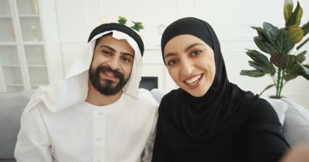 POV of Arabs muslim married couple talking to camera when having videochat. Male and female Arabians videochatting and smiling. Beautiful woman and handsome man at home speaking in webcam. Middle East — Stock Video