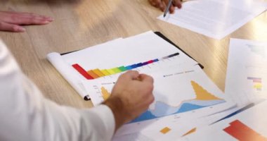 Kağıt bilgileriyle masaüstünü kapat. İş adamları kağıt sürümünü kullanarak çizelgeleri ve belgeleri gözden geçiriyorlar. Beyin fırtınası.