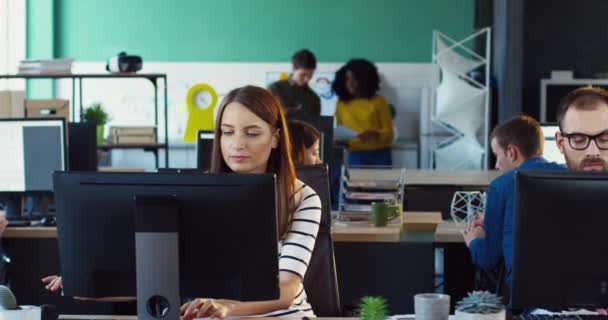 Jovem gerente de escritório afro-americano em camisa xadrez e óculos verifica o trabalho de novos funcionários. Trabalho no escritório. Trabalho em equipa. — Vídeo de Stock