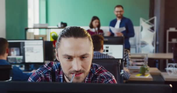 Bilgisayarda çalışan beyaz bir gencin portresini yakından çek. Ekrana odaklan. Modern ofiste müteahhit işi kavramı.. — Stok video