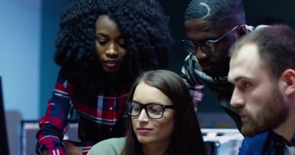Mladá skupina kancelářských pracovníků, stojící na konci pracovního dne poblíž pracoviště a projektu mozkového kmene. Krásná africká americká žena dělat poznámky pro tým. — Stock video