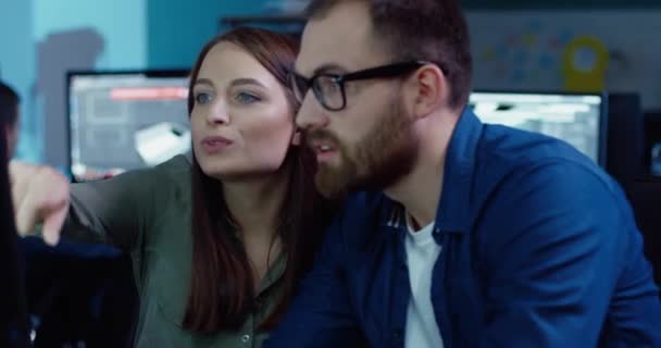 Two employees work together on project sitting at the same computer. Beautiful girl gives idea to partner, Caucasian man with glasses nods. — Stock Video