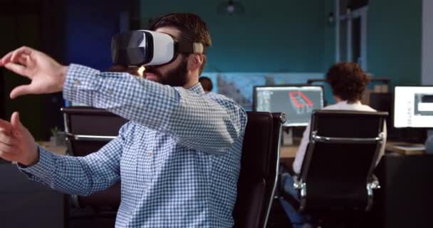Handsome office worker with beard in plaid shirt working wearing helmet of virtual reality. Using of new technologies in work of the designer. — Stock Video
