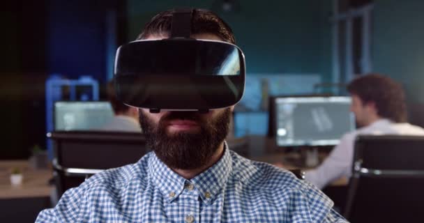 Guapo oficinista caucásico con barba trabaja usando casco de realidad virtual. Utilización de las nuevas tecnologías en el trabajo. — Vídeo de stock