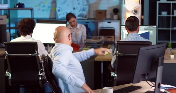 En flintskallig man i vit skjorta som jobbar på kontoret vid datorn. Affärsman glädjer sig över framgång och delar glädje med laget. — Stockvideo