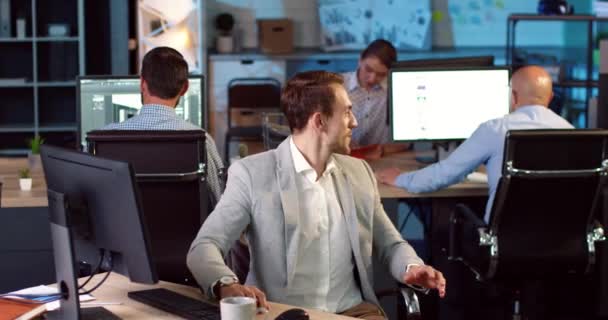 Felnőtt irodai dolgozó zakóban nézi a képernyőt és jó híreket kap. Boldog ember reagál érzelmileg, és megosztja öröm a siker a kollégákkal. — Stock videók