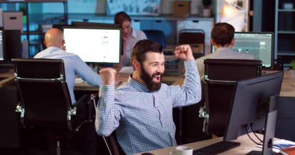 Счастливый европеец делится хорошими новостями с коллегами в офисе. Взрослый бородатый мужчина доволен успешным результатом. — стоковое видео