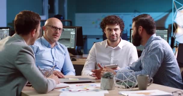 Gruppo di uomini d'affari seduti a tavola a negoziare. Business meeting termina con una stretta di mano tra due uomini adulti. — Video Stock