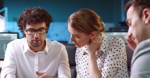 Bir grup iş analisti masa başında belgelerle oturuyor. Gözlüklü yakışıklı ofis çalışanı kadınlara yeni projenin ne olduğunu açıklıyor. — Stok video