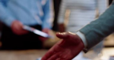 El sıkışan iki adama yaklaş. Afrikalı Amerikalı bir adam elini beyaz bir adama uzatıyor. Ağır çekim. Takım ritüeli. Anlaştık..