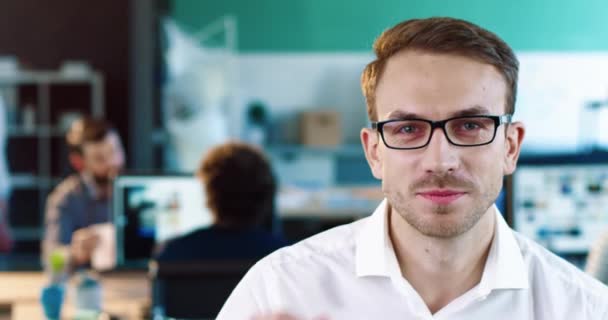 Detailní záběr portrét šťastného bělocha s pěkným vzhledem upravuje brýle a směje se pohledy do kamery. — Stock video