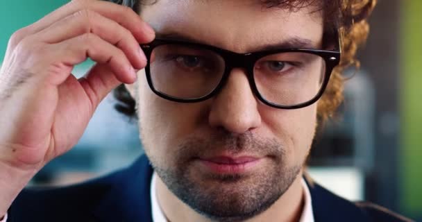 Close-up portret van jonge Kaukasische succesvolle zakenman in pak neemt af bril en glimlacht op camera. — Stockvideo