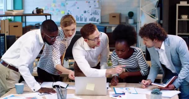 Le jeune chef de projet en chemise blanche et lunettes confie la tâche à ses subordonnés. Travailler au bureau. Répartition des responsabilités. — Video