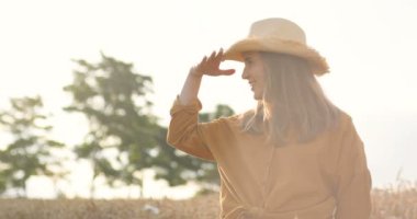 Neşeli, güzel, gülen yüzlü, dışarıda kamp yapan bir kadın. Güneşli bir günde tarlada dikilen şapkalı, gülümseyen güzel beyaz kız portresi. Kırsal kavram