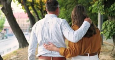 Kafkasyalı bir babanın yetişkin güzel bir kızla kucaklaşarak caddede yürümesi ve konuşması. Konuşurken. Açık havada. Kız ve erkeğin gezintilerine, kucaklaşmalarına ve konuşmalarına. Sarılmak..