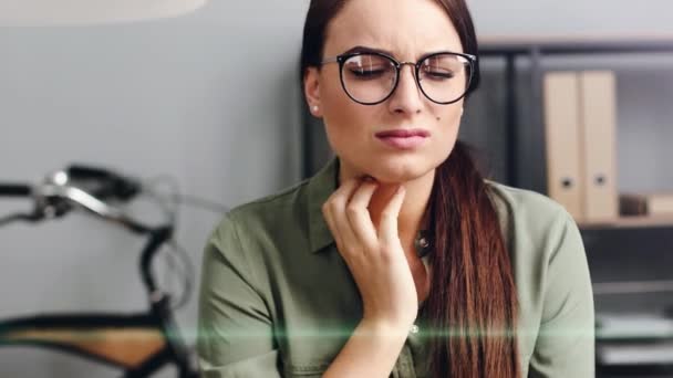 Close up of beautiful woman working on laptop in modern office. Tired girl sitting at work touches her neck feeling sore throat. — Stock Video