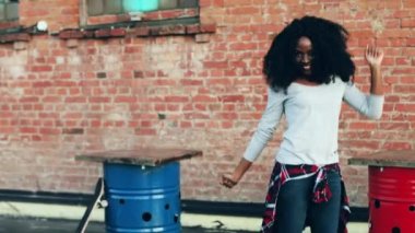 Terasta dans eden genç ve güzel bir kız. Kıvırcık siyah saçlı neşeli Afrikalı Amerikalı kadın çatıda hareketli.