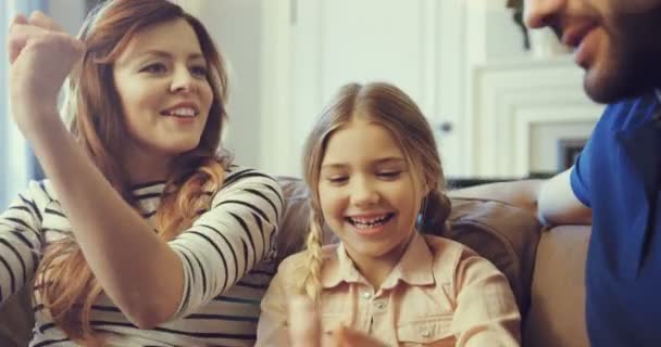 Joyeux papa et maman jouant avec leur fille dans une atmosphère confortable à la maison.Les jeunes parents et les enfants drôles s'amusent à jouer au jeu de style de vie. — Video