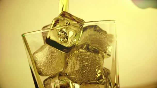 木製のテーブル背景 アイス キューブ 焦点に氷でガラスのバーマン注ぐウィスキー ウイスキー リラックス時間 金の温かみのある雰囲気 — ストック動画