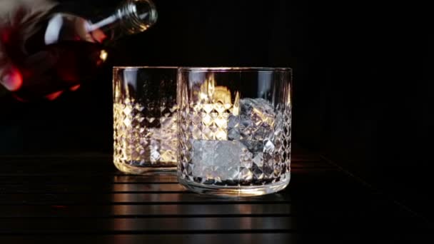 Barman Pouring Whiskey Two Glasses Ice Cubes Wood Table Black — Stock Video