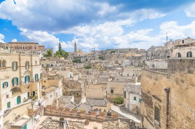 panoramik tipik taşlar (Sassi di Matera) ve kilise Matera Unesco Avrupa kültür başkenti 2019 altında mavi gökyüzü beyaz bulutlar, Basilicata, İtalya
