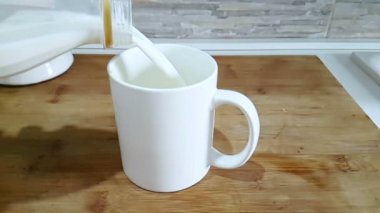 mutfak arka planda, ağır çekim, diyet ve sağlıklı beslenme kahvaltı konsepti ile çekim cam içme içine dökme taze beyaz süt