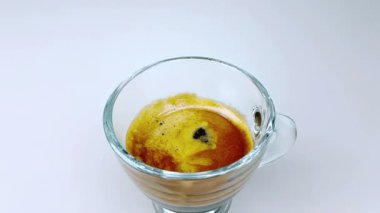 kahve köpüğü ile İtalyan kahve espresso fincan trasparent içinde ağır çekimde beyaz ışık arka plan üzerinde gıda düşen bırakın ve içki ve kavramı relax
