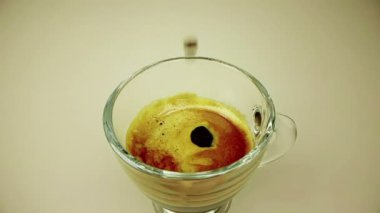 kahve damla altın sıcak üzerinde köpük ile İtalyan kahvesi arka plan, yiyecek ve İçecek ışık ve rahatla espresso fincan trasparent içinde ağır çekimde düşüyor