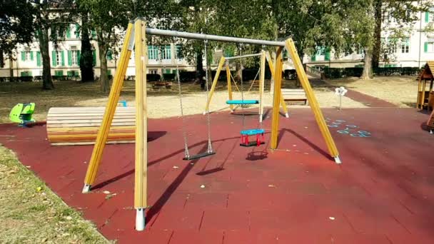 Empty swings with chains swaying at playground for — Stock Video