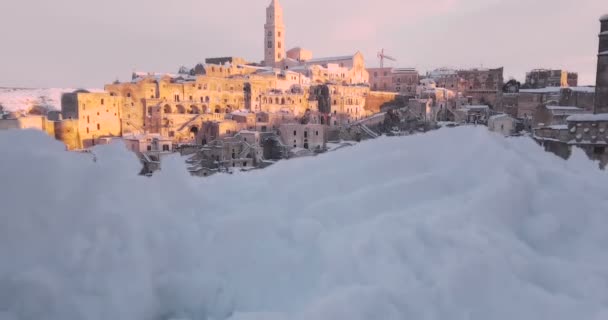 Gyönyörű kilátás nyílik a tipikus kövek Sassi di Matera és templom Matera 2019 a hó a ház, az utazás fogalma és — Stock videók