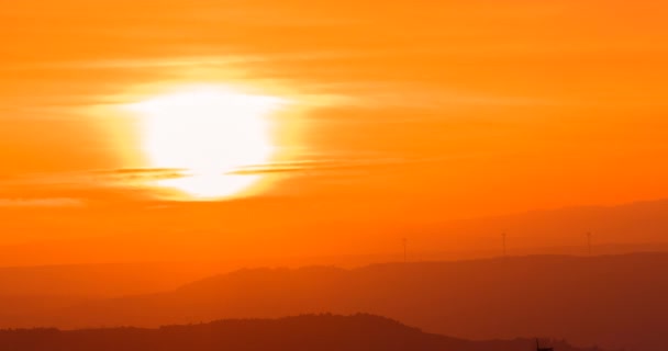 Scena del tramonto con sole cadere dietro le nuvole e le montagne sullo sfondo, time-lapse shot, caldo colorato — Video Stock