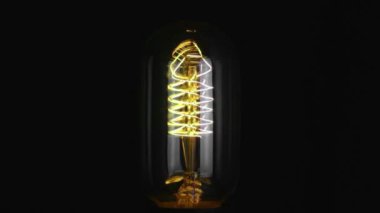 Yavaş çekimde aç ve kapat, eski teknolojiye sahip antika ampulü sıcak ışık sarısı filamanla donat