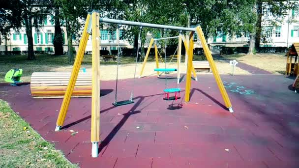 Altalene vuote con catene ondeggianti al parco giochi per bambini, mosse dal vento, lente — Video Stock