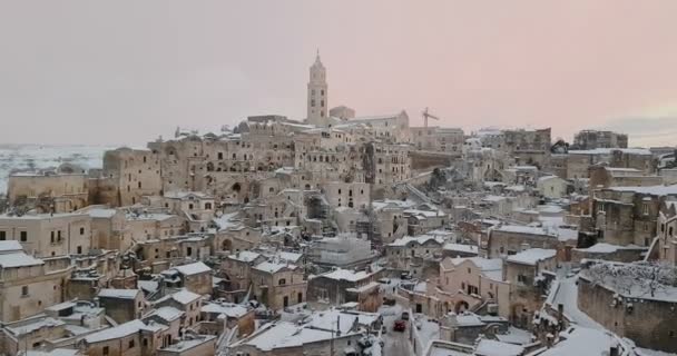 Gyönyörű kilátás nyílik a tipikus kövek Sassi di Matera és templom Matera 2019 a hó a ház, az utazás fogalma és — Stock videók