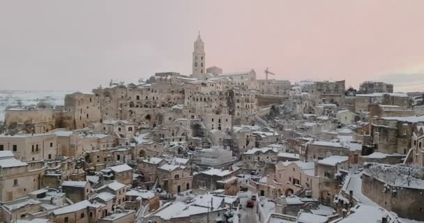 Панорамный вид на типичные камни Sassi di Matera и церковь Matera 2019 со снегом на доме, концепция путешествия и — стоковое видео