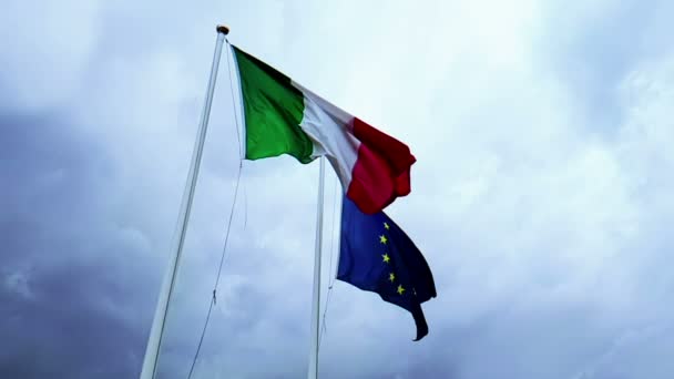 Размахивая текстурой ткани флага Италии и союза Европы на голубом небе с — стоковое видео