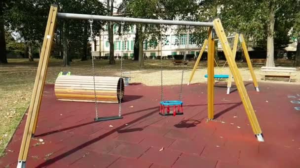 Prázdné houpačky s řetězy kymácející se na dětském hřišti, pohyboval se od větru, pomalu — Stock video