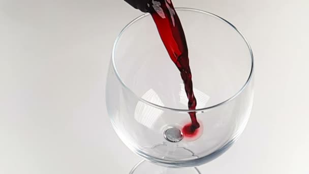 Χύνοντας κόκκινο κρασί σε ποτήρι ποτό σε λευκό φόντο, διατροφή έννοια της υγειονομικής περίθαλψης, γυρίσματα σε αργή — Αρχείο Βίντεο