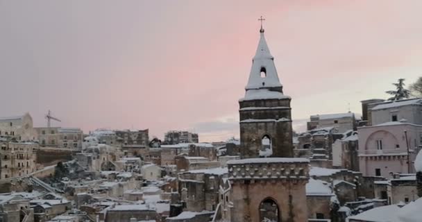 典型的な石のアッシ・ディ・マテーラとマテーラ2019の教会のパノラマビュー、家の上に雪、旅行の概念と — ストック動画