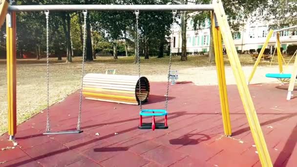 Leere Schaukeln mit schwankenden Ketten auf Kinderspielplatz, vom Wind bewegt, langsam — Stockvideo