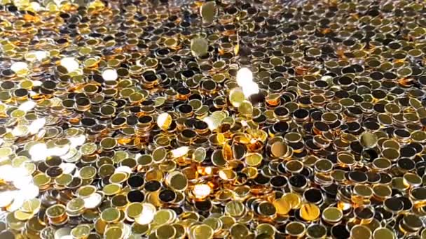 Spadający złoty brokat folia konfetti, bardzo powolny ruch na złotym tle, wakacje i świąteczne — Wideo stockowe