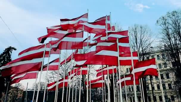 Łotewskie flagi przymocowane do słupa machającego na wietrze, panorama Rygi, Łotwa, koncepcja — Wideo stockowe
